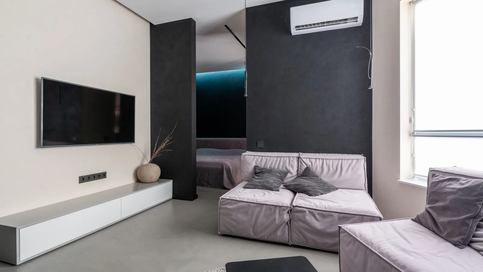 Wall-mounted mini split for basement best choice in a modern low-ceiling living space with dark gray walls