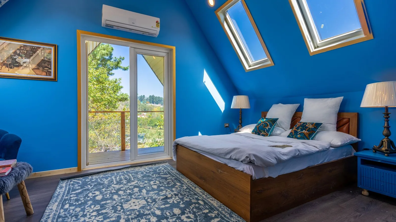 White ductless mini split indoor unit on a bright blue bedroom wall above a sliding glass door, perfect for those seeking online mini split deals